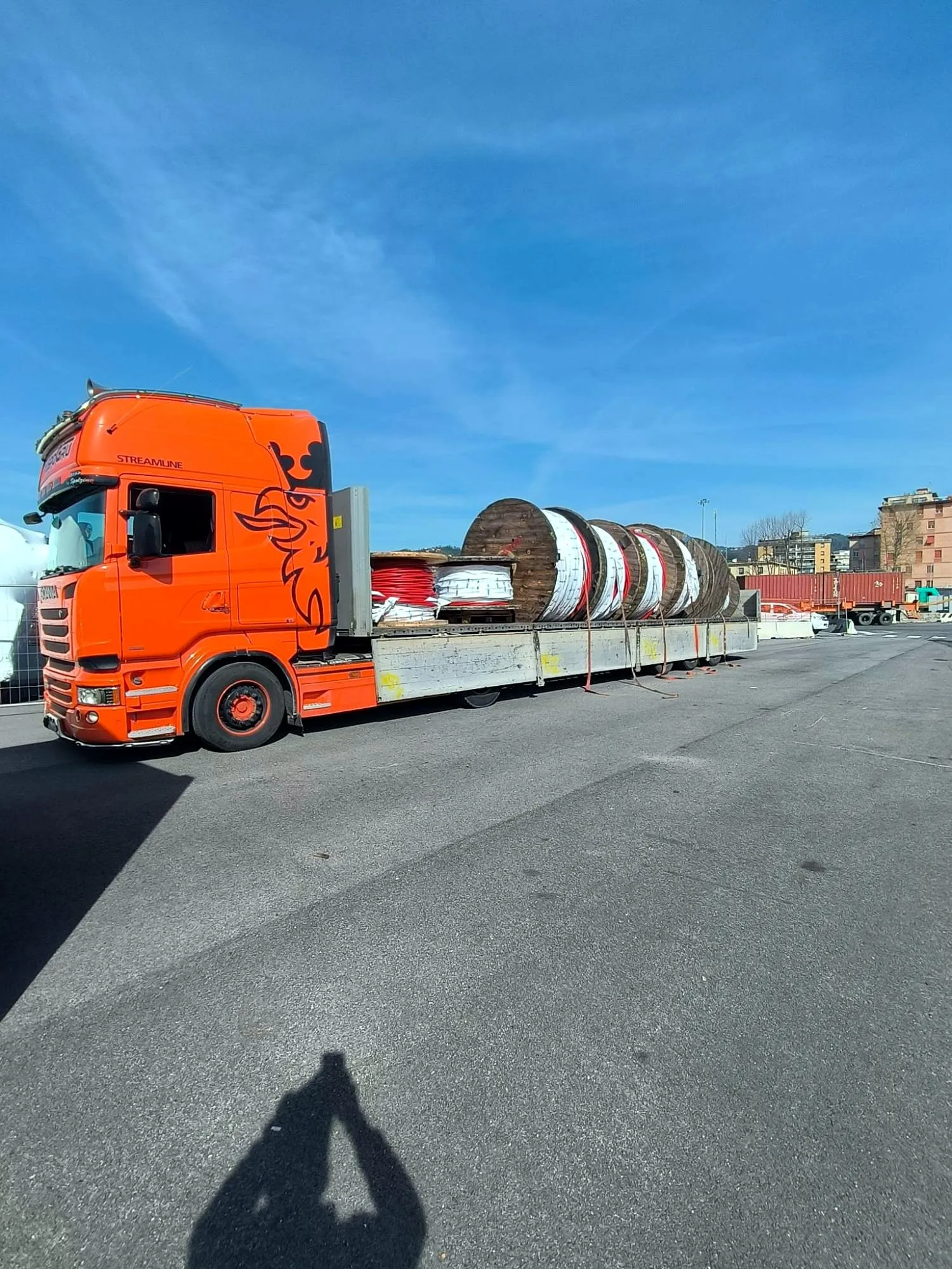 Scania R450 arancione con bobine di cavo legate sul pianale